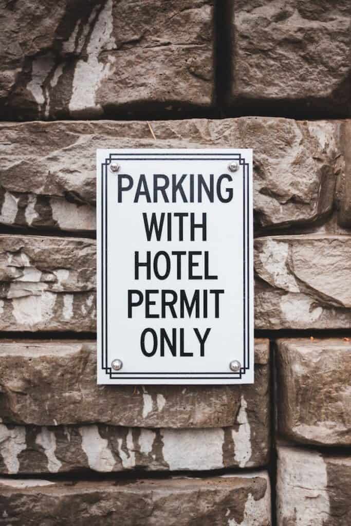 Signboard with inscription about parking on stone wall