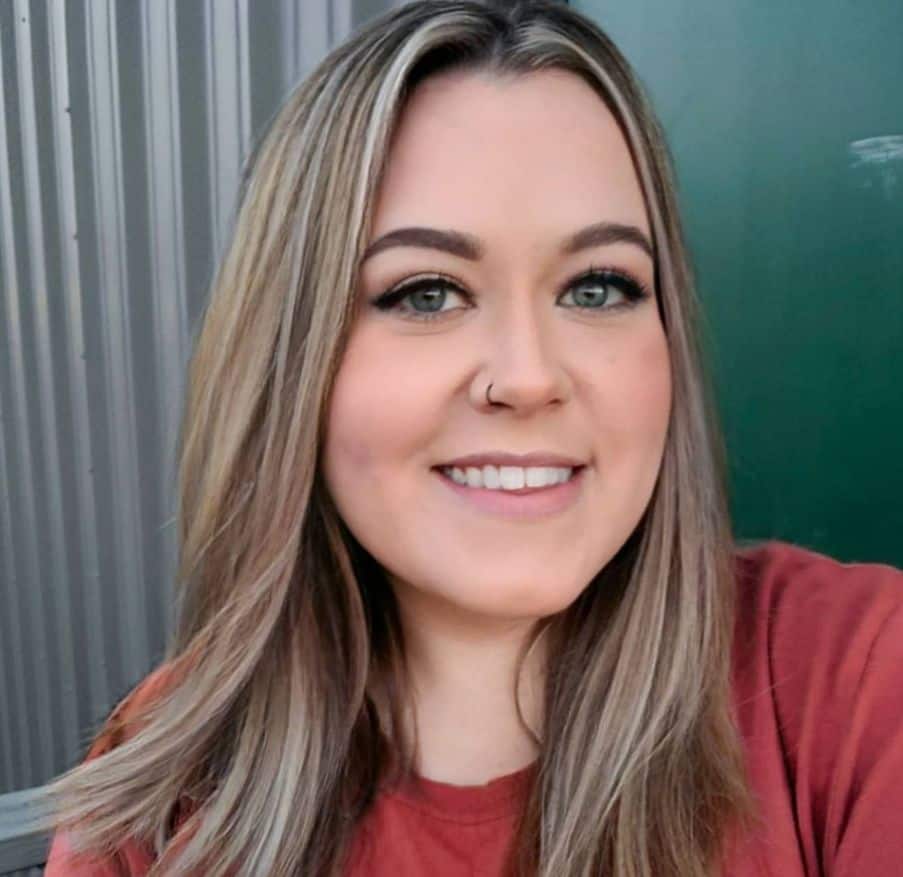 A woman in a red shirt smiling for the camera.