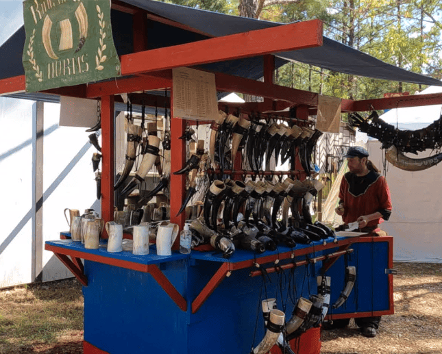 Merchant tent selling handmade horns and cups.