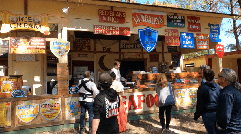 Food booth selling  turkey legs,  roasted vegetables, Jambalaya, seafood, and more.