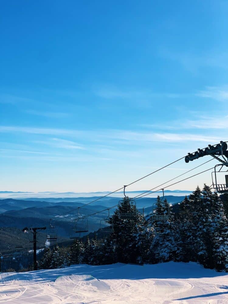 ski lift on snow-covered mountain under blue sky during daytime